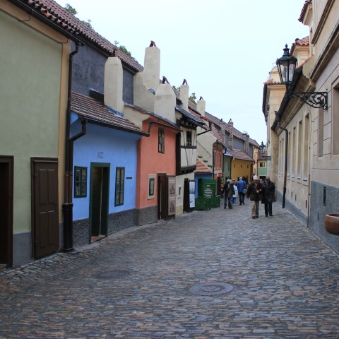 a group of people walking down a sidewalk in front of Golden Lane